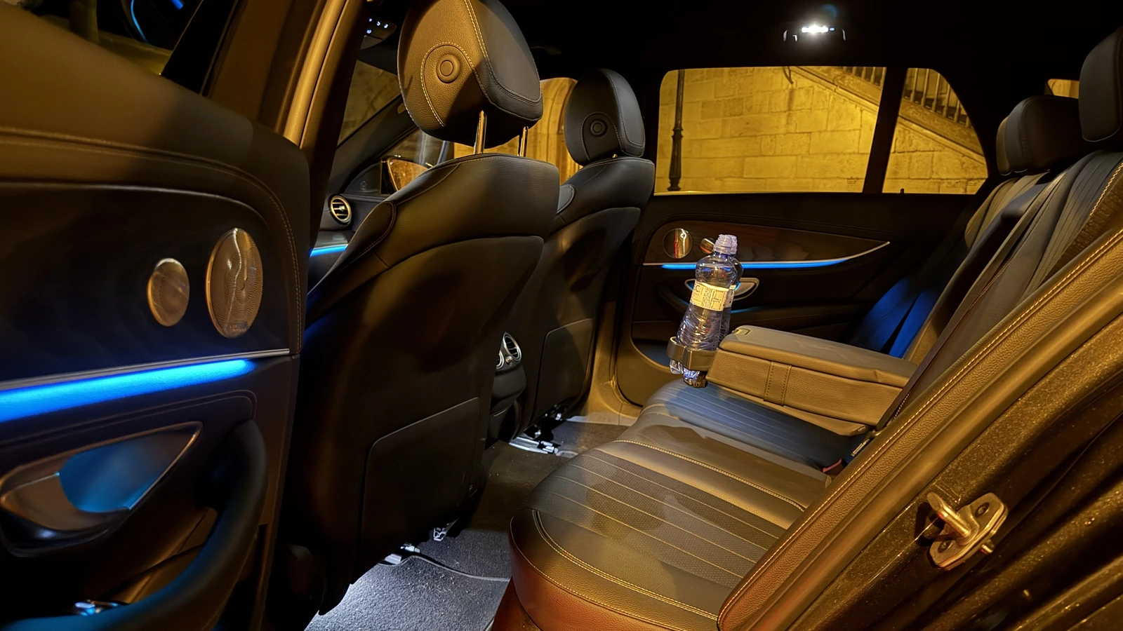 Rücksitze einer Mercedes-Benz E-Klasse mit Ambientebeleuchtung und Wasser an Bord